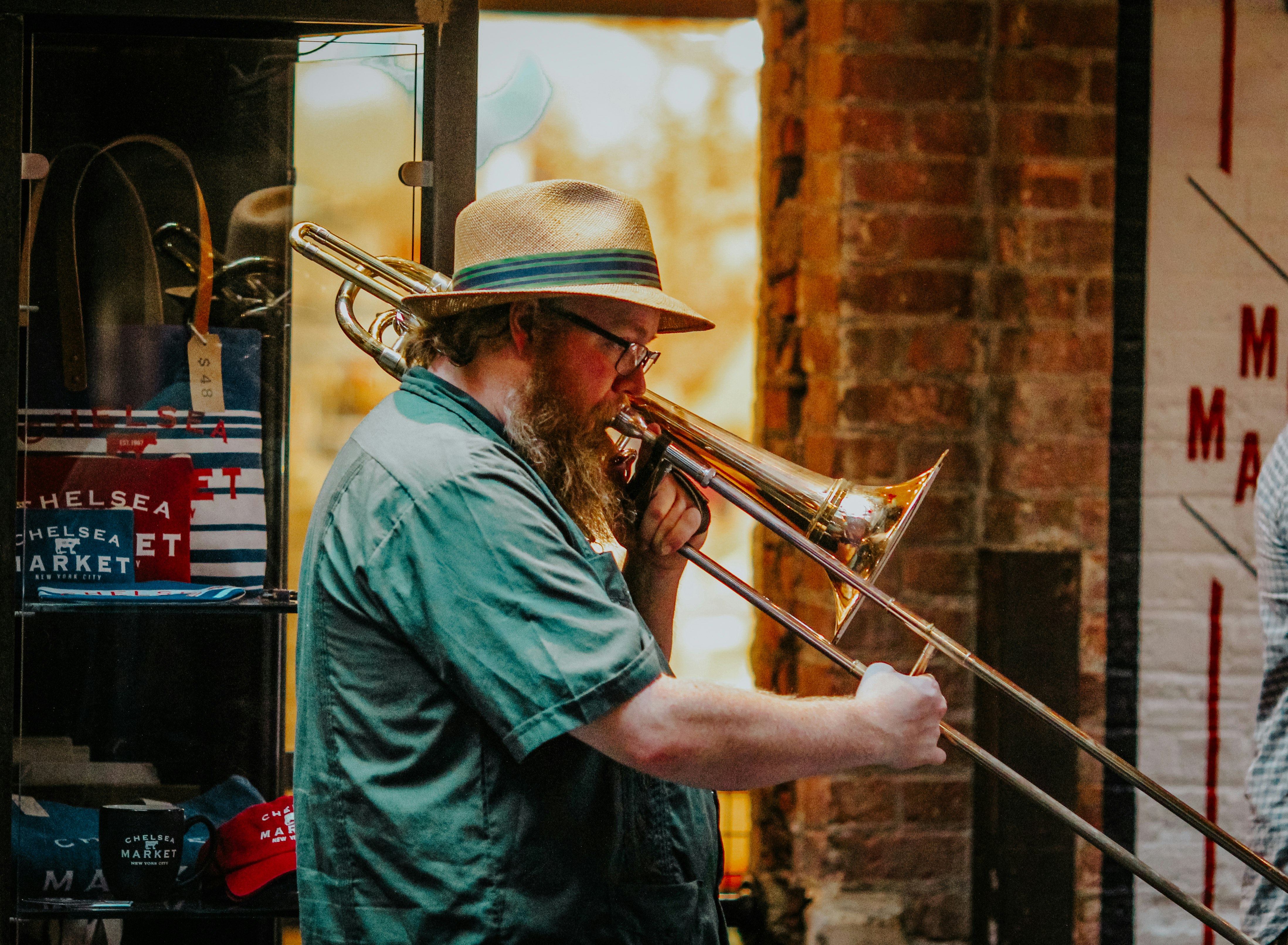 man in green dress shirt playing trumpet